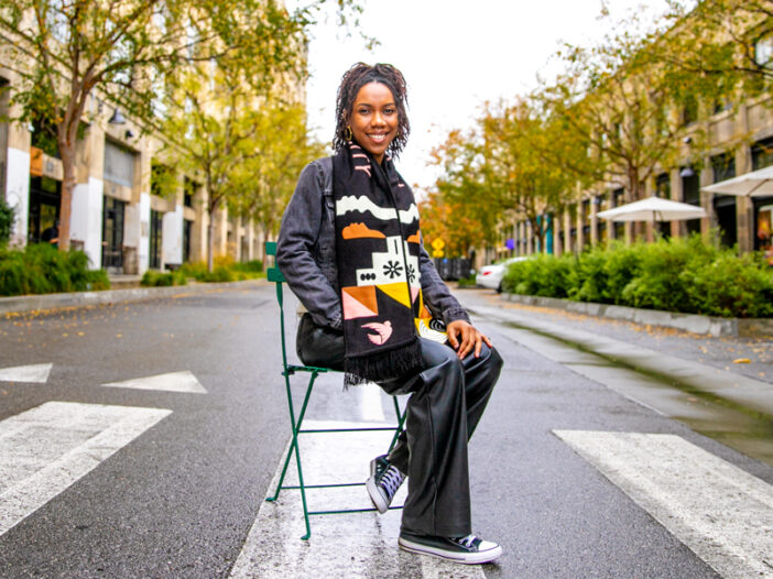 A young woman sits in a chair in a crosswalk